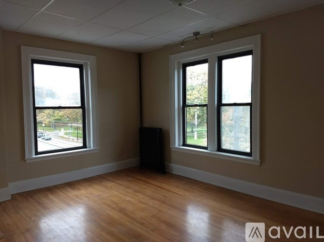 A room with wooden floors and two windows.