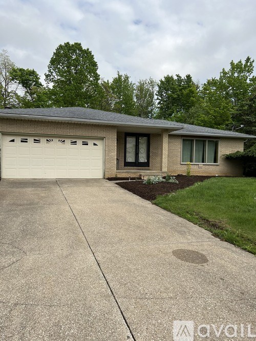 A house with a grey roof and a white garage door.