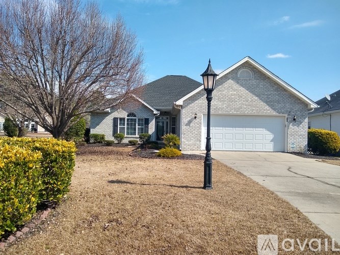 A house with a driveway and a lamp post in front.