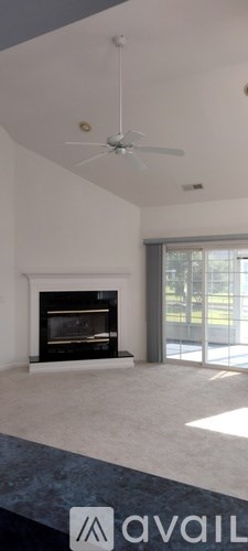A modern living room with a fireplace and a ceiling fan.