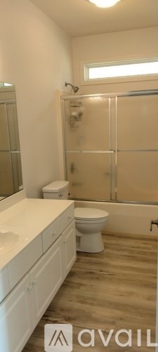 A bathroom with a toilet, sink, and shower.