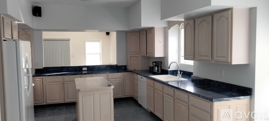 A kitchen with a black counter top and wooden cabinets.