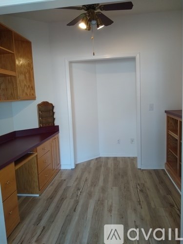 A kitchen with wooden cabinets and a ceiling fan.