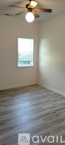 A room with a ceiling fan and a window.