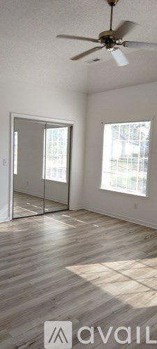 A room with a ceiling fan and a sliding glass door.