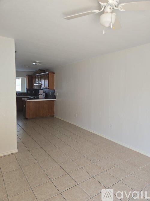 A room with a ceiling fan and tiled floor.