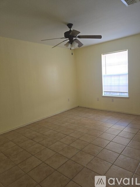 A room with a ceiling fan and tiled floor.