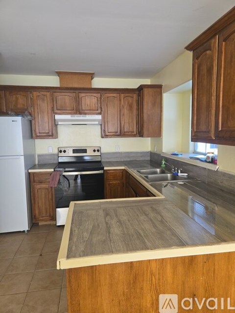 A kitchen with wooden cabinets and a white refrigerator.