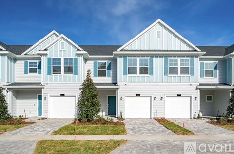 A large two-story house with a garage on the first floor and a balcony on the second floor.