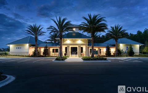 A building with palm trees in front of it at night.