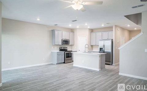 A spacious kitchen with a refrigerator, microwave, and oven.