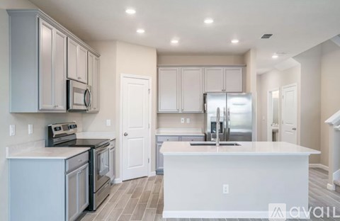 A kitchen with white cabinets and a white island.