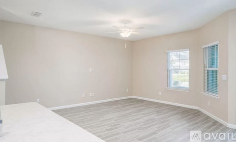 A room with a white floor and a window with blinds.