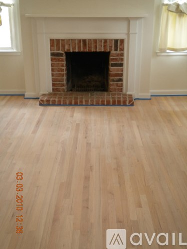 A room with a fireplace and wooden floors.