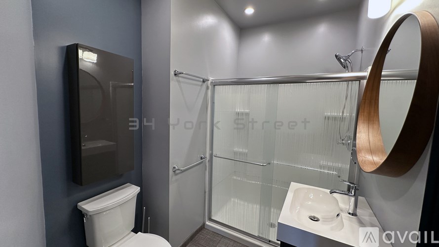 A modern bathroom with a toilet, sink, and mirror.