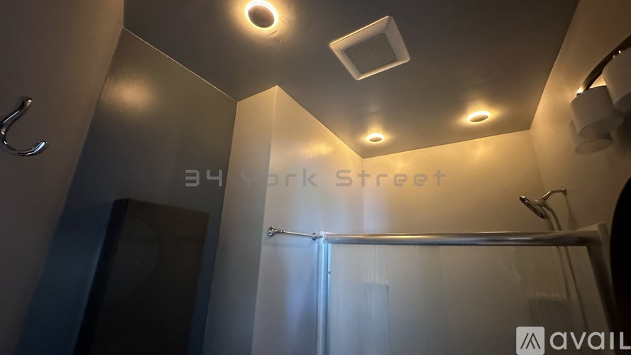 A bathroom with a glass shower door and a sign that says Black Street.