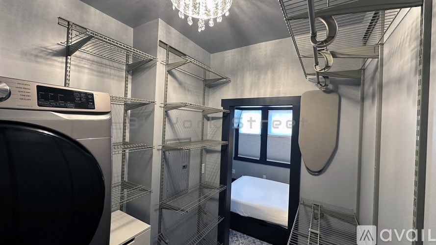 A laundry room with a washer and dryer, shelves, and a window.