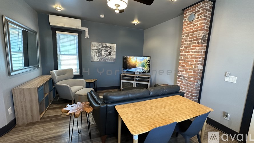 A living room with a brick wall and a wooden table.