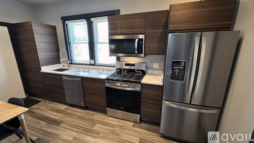 A kitchen with a refrigerator, stove, and microwave.