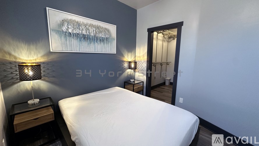 A bedroom with a bed, nightstands, and a painting on the wall.