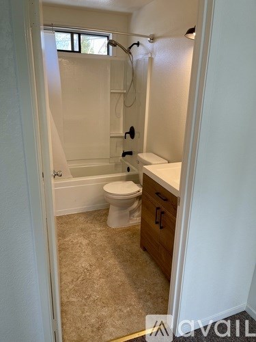 A bathroom with a toilet, sink and bathtub.