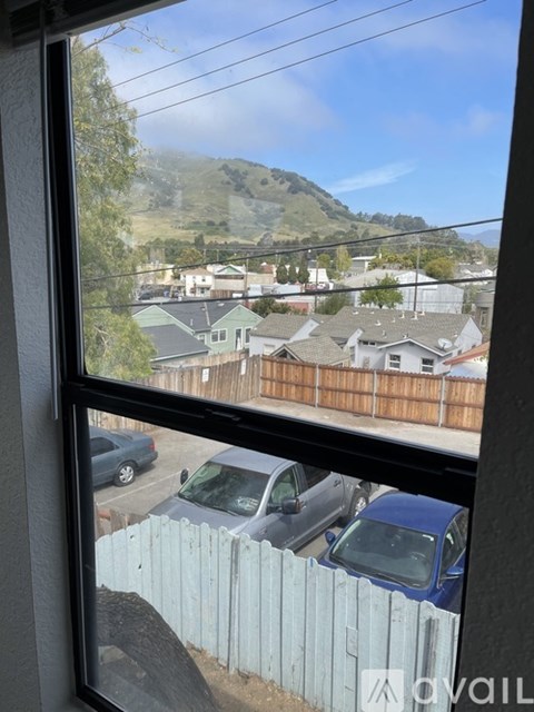A view from a window looking out at a parking lot and houses.