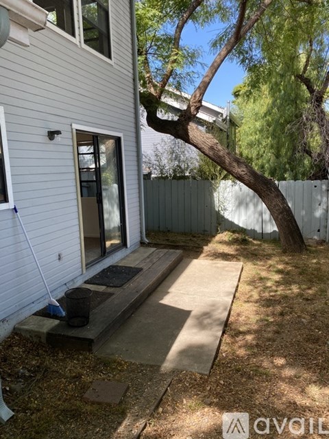 A white house with a tree in front.