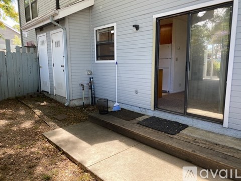 A house with a grey siding and a white door is for sale.
