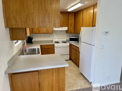 A kitchen with wooden cabinets and a white refrigerator.