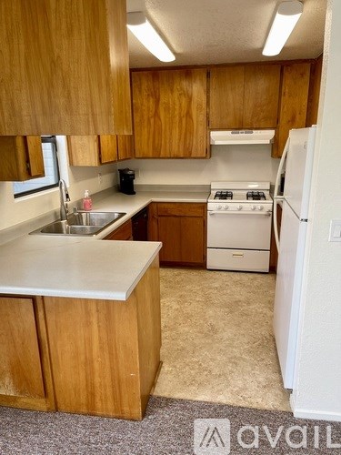 A kitchen with wooden cabinets and a white fridge.