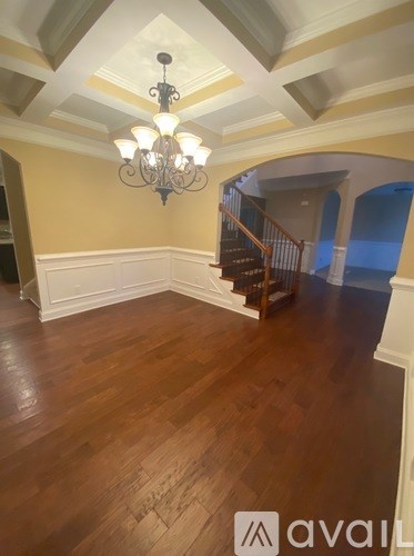 A room with wooden floors and a chandelier.