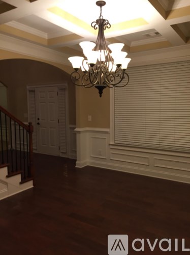 A chandelier hangs over a staircase in a home.