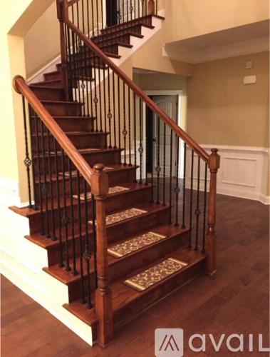 A wooden staircase with a metal railing.
