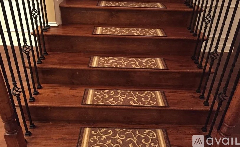 A set of stairs with a carpeted runner and metal balusters.