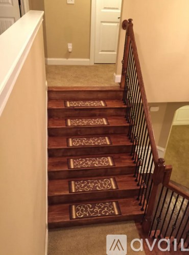 A staircase with a carpeted floor and a white door in the background.