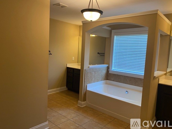 A bathroom with a tub, sink, and mirror.