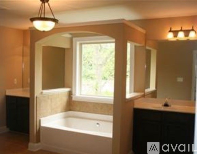 A bathroom with a tub and a window.