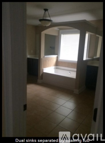 A bathroom with dual sinks separated by a soaking tub.