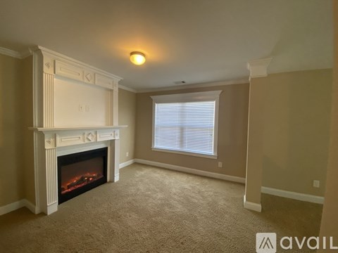 A living room with a fireplace and a white mantle.