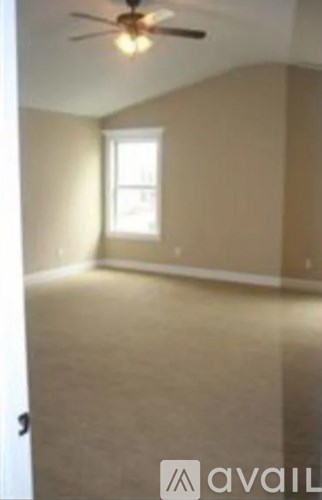 A room with a ceiling fan and a window.