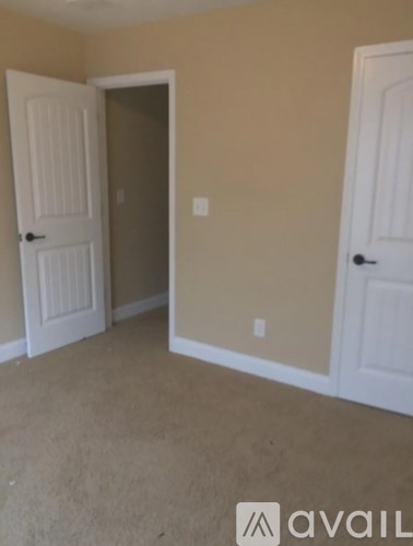 A room with two white doors and a carpeted floor.