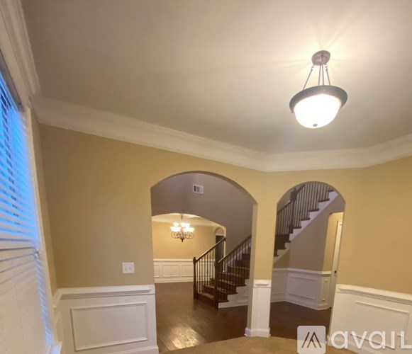 A well-lit foyer with a staircase and a chandelier.