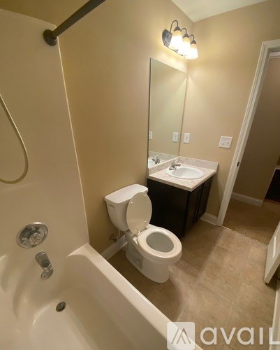 A bathroom with a toilet, sink, and mirror.