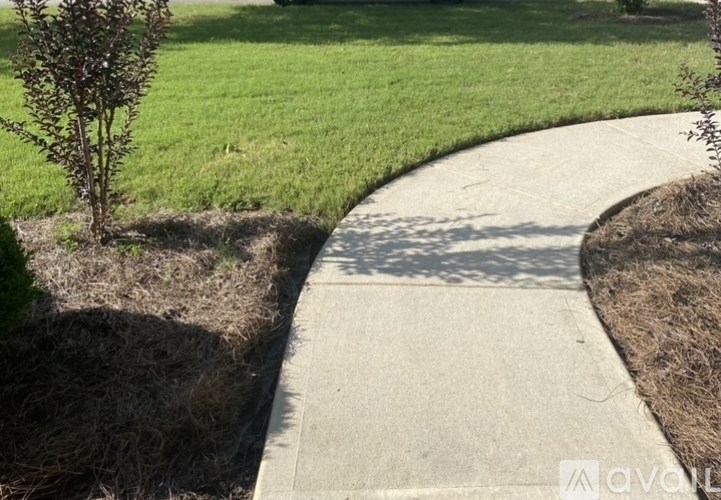 A concrete pathway leads through a grassy area.