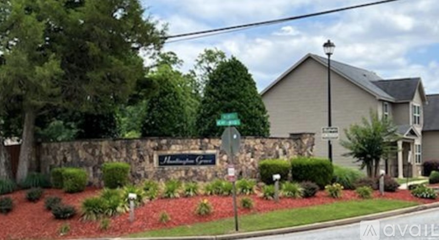 A sign that says "Maple Grove" is in front of a house.