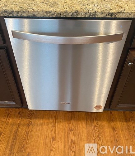 A stainless steel dishwasher with a single handle on the door.