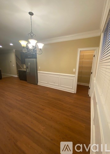 A room with wooden floors and a chandelier hanging from the ceiling.