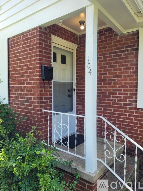 A white door with a mailbox on a brick wall.
