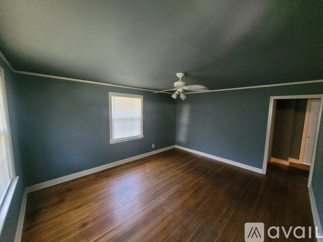 A room with a ceiling fan and a window.