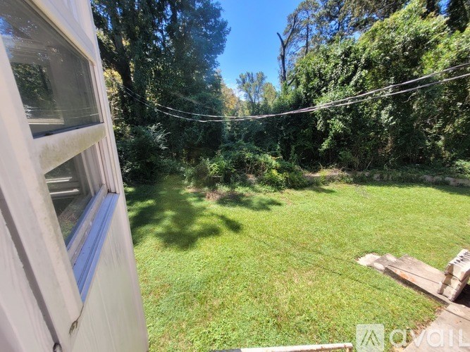 A backyard with a wooden deck and a green lawn.